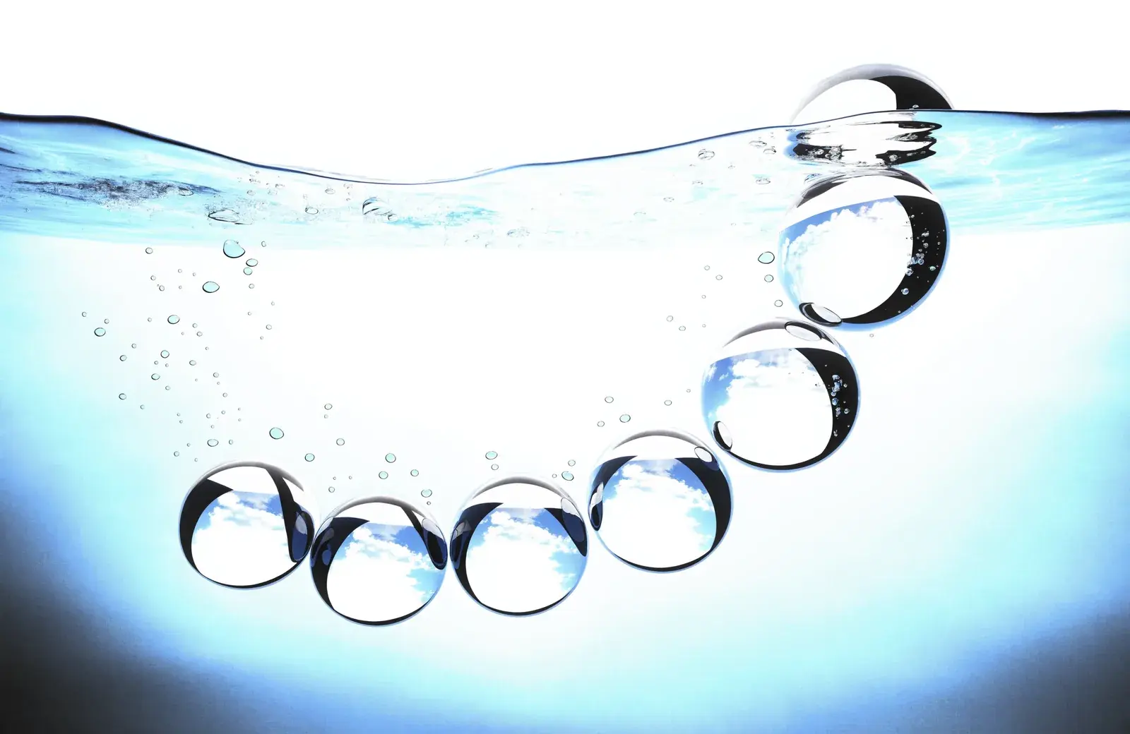 A curved chain of clear spheres rising through blue water toward the surface.