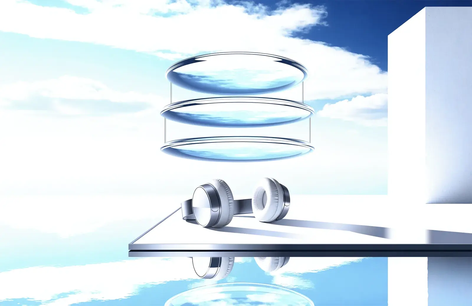 Three clear glass discs stacked beside headphones on a bright blue poolside terrace.